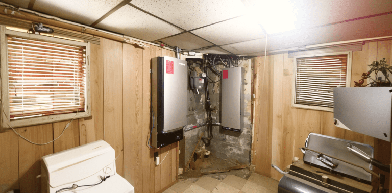 Solanta wall-mounted battery storage units installed in a basement utility room with electrical wiring and conduit.