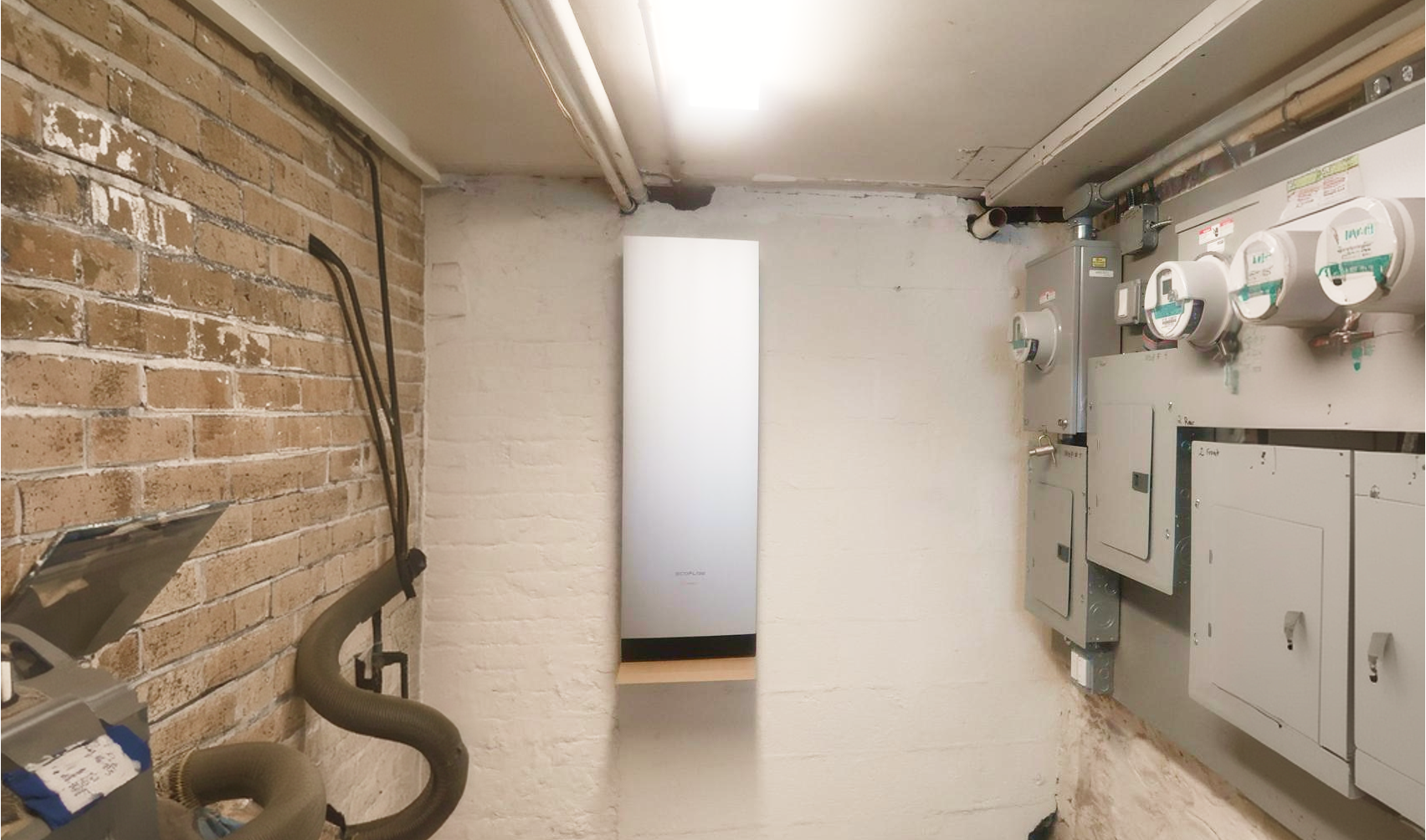 Wall-mounted home battery backup system installed in a basement beside residential electrical panels and utility meters.